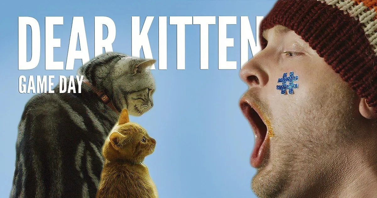 A man in a beanie with a blue hashtag on his cheek, yelling, with a cat and kitten looking up at him.