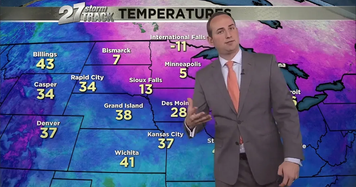 A weather presenter stands in front of a map displaying temperatures across the Midwest.