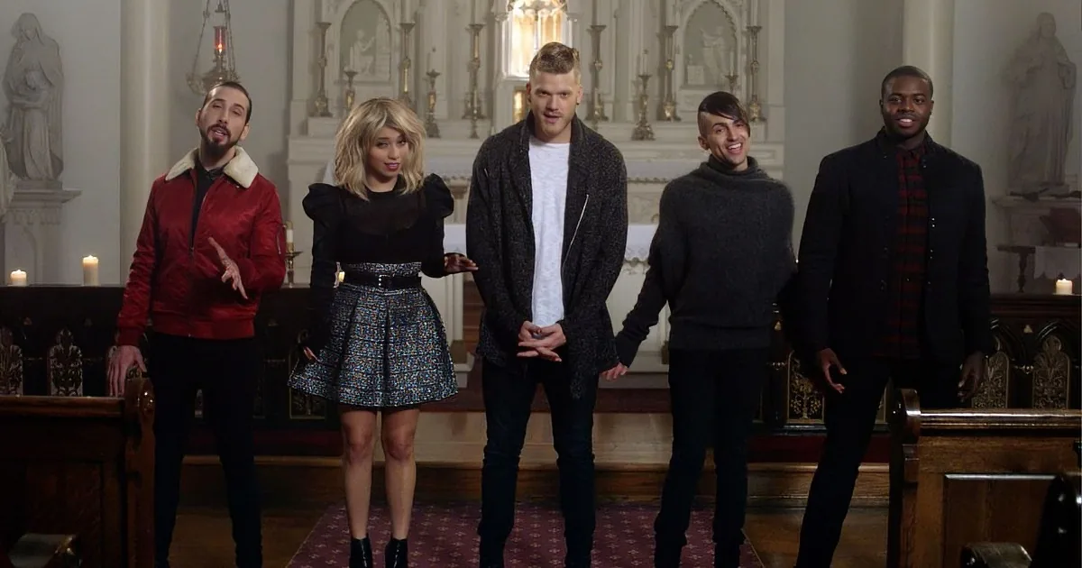 A group of five people stands in a church, dressed in stylish outfits, with a woman in the center wearing a black dress...