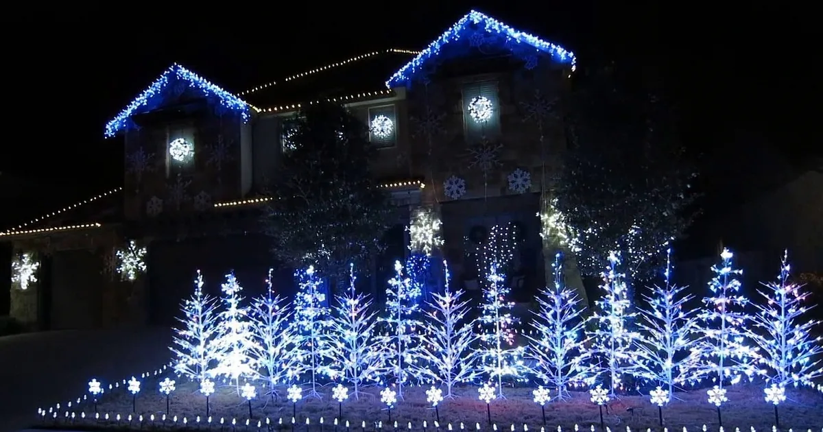 A house adorned with blue and white Christmas lights and snowflake decorations.