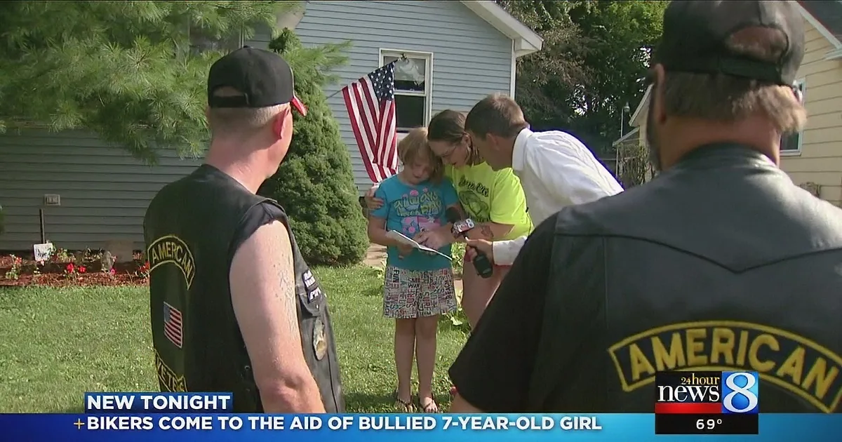A group of people, including a young girl, is being interviewed by a news reporter in front of a house.