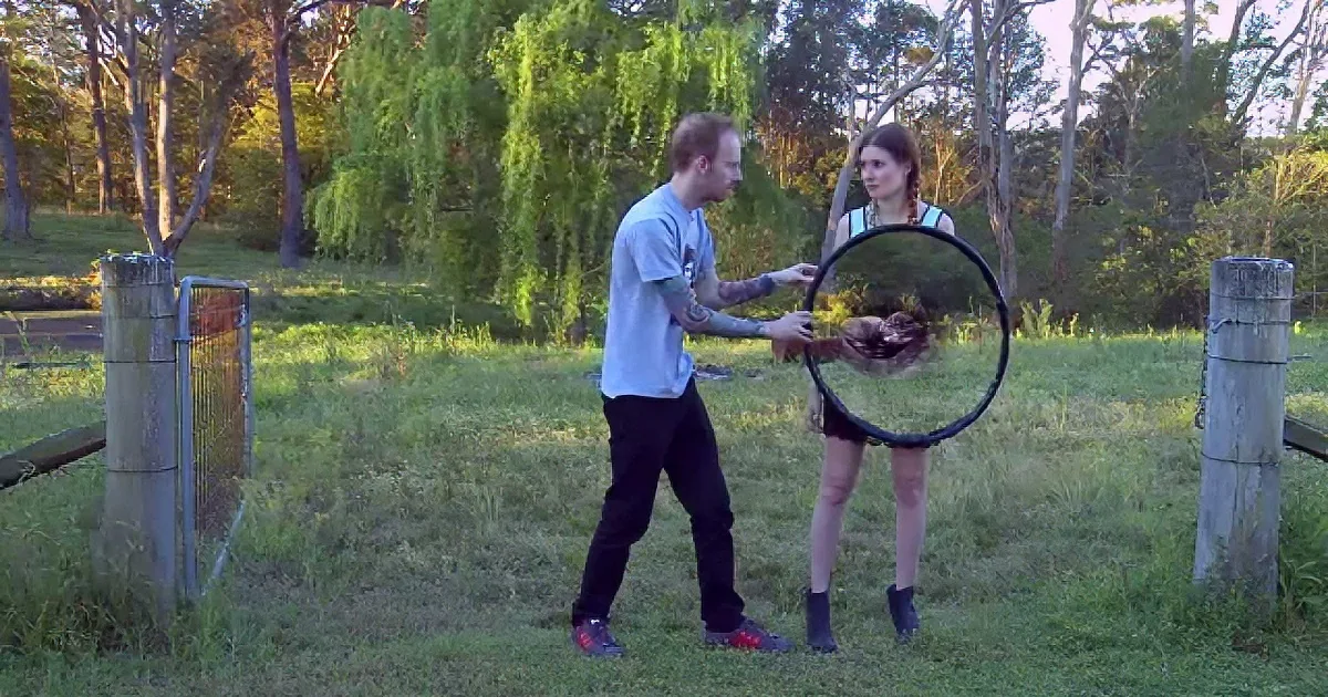 Australian Man and Woman Stand in Field With Mirror. What He Does With It Made Me Gasp.