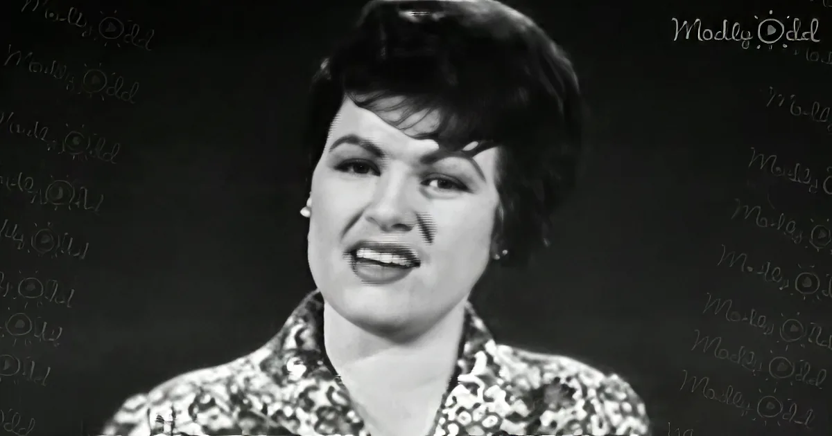 A woman with dark hair and a patterned blouse is shown in a black-and-white image.