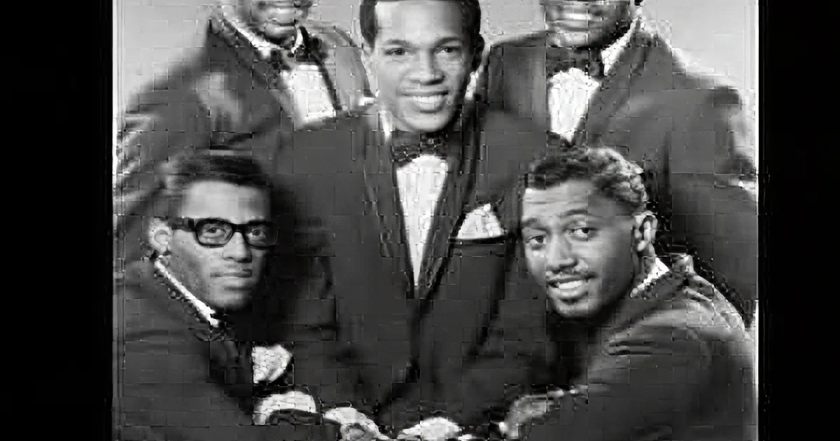 A black-and-white photo of a group of five men in suits and bow ties, posing together.