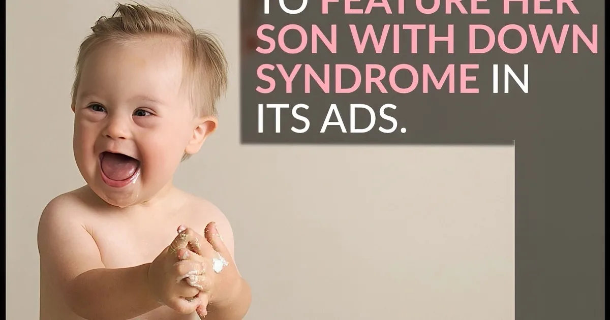 A smiling toddler with Down syndrome is covered in white substance, holding a small object.