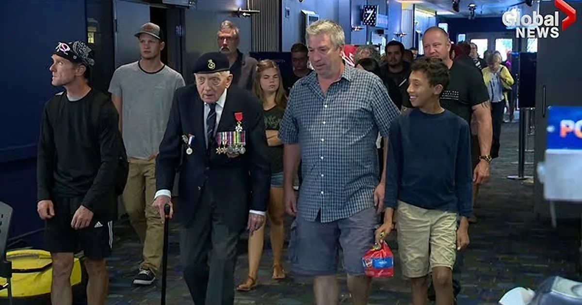 An elderly man in a military uniform with medals and a young boy in a blue sweater stand together, possibly at an airport.