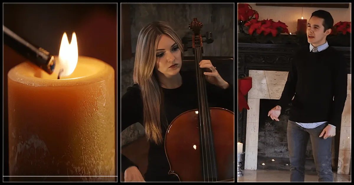 A lit candle, a woman playing cello, and a man singing in front of a fireplace with poinsettias.