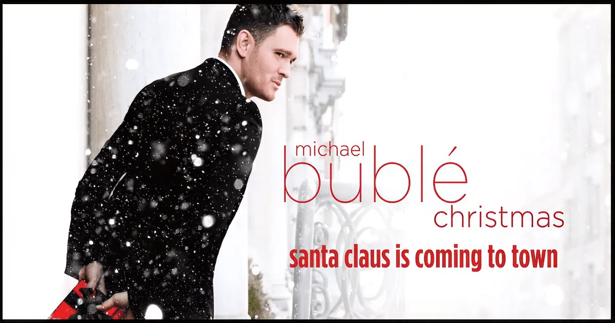 Michael Bublé in a black suit holding a red gift, snow falling, Christmas album cover.