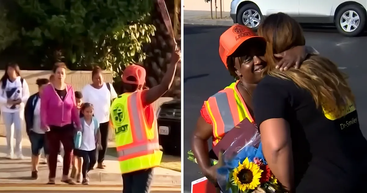 A crossing guard in a high-visibility vest directs pedestrians while another person hugs her, holding flowers.