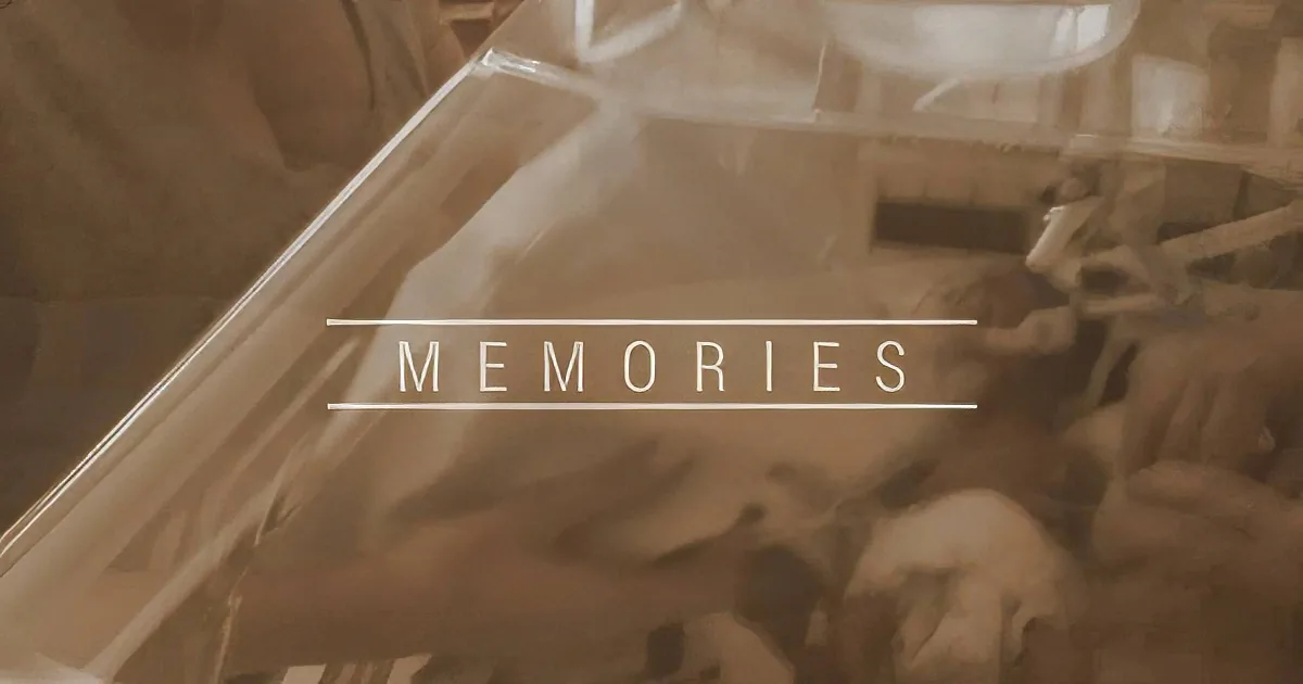 A sepia-toned image of a person's hand holding a glass, with the word "MEMORIES" overlaid.