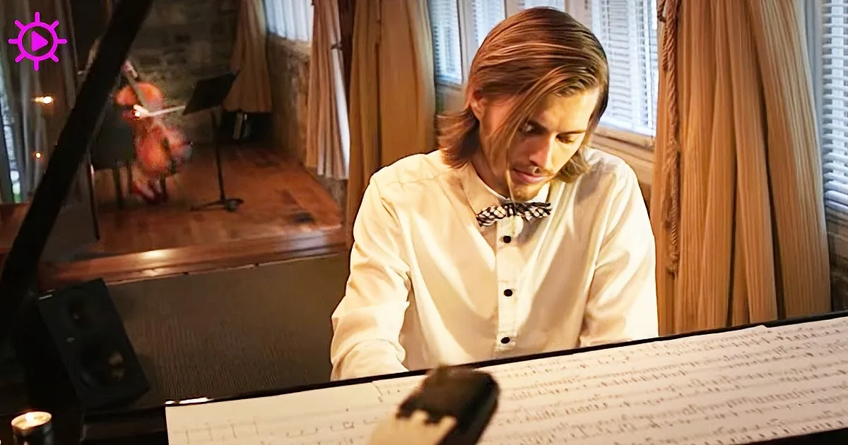 A man in a white shirt and bow tie sits at a piano, looking down at sheet music.