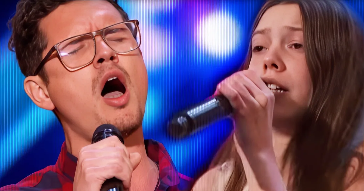 A man and a woman are singing passionately into microphones on a stage with blue lighting.