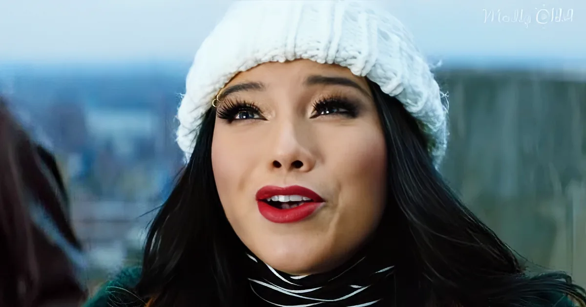 A woman wearing a white knit hat and a striped turtleneck, looking upwards with a cityscape in the background.