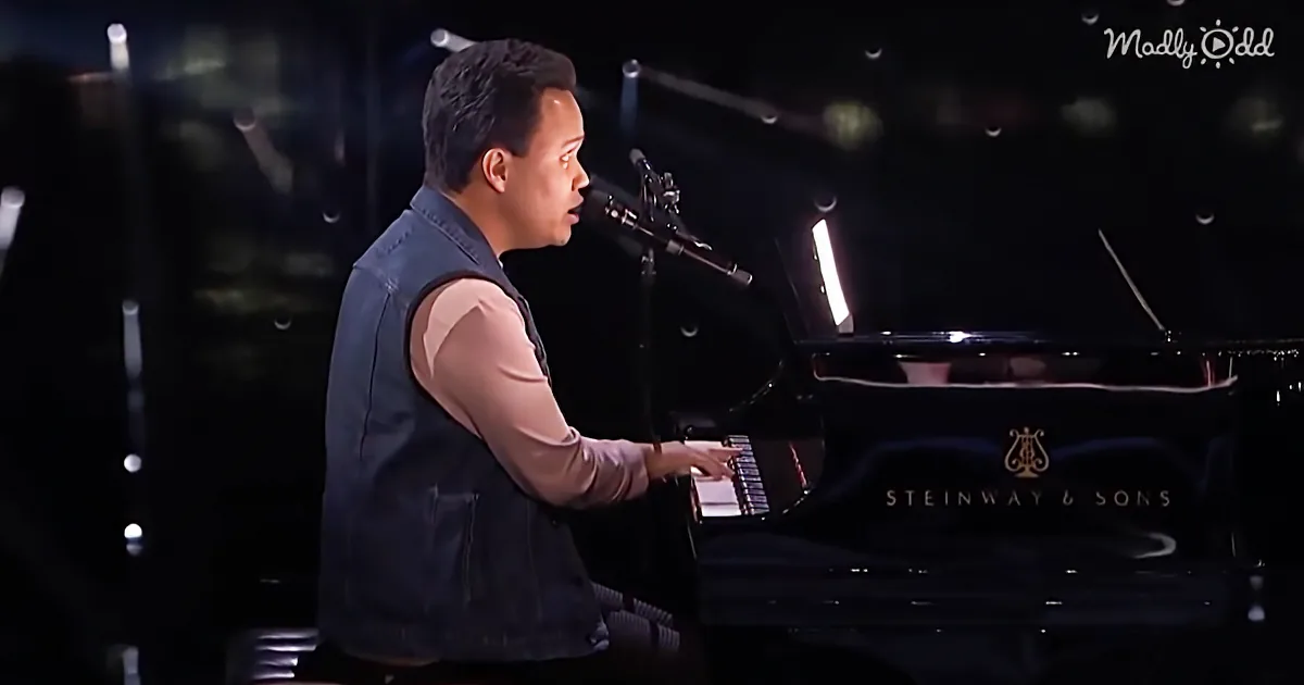 A man in a vest plays a Steinway & Sons grand piano, singing into a microphone.