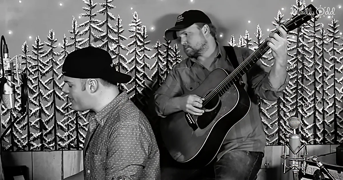 Two men sing and play guitar in a snowy forest backdrop.