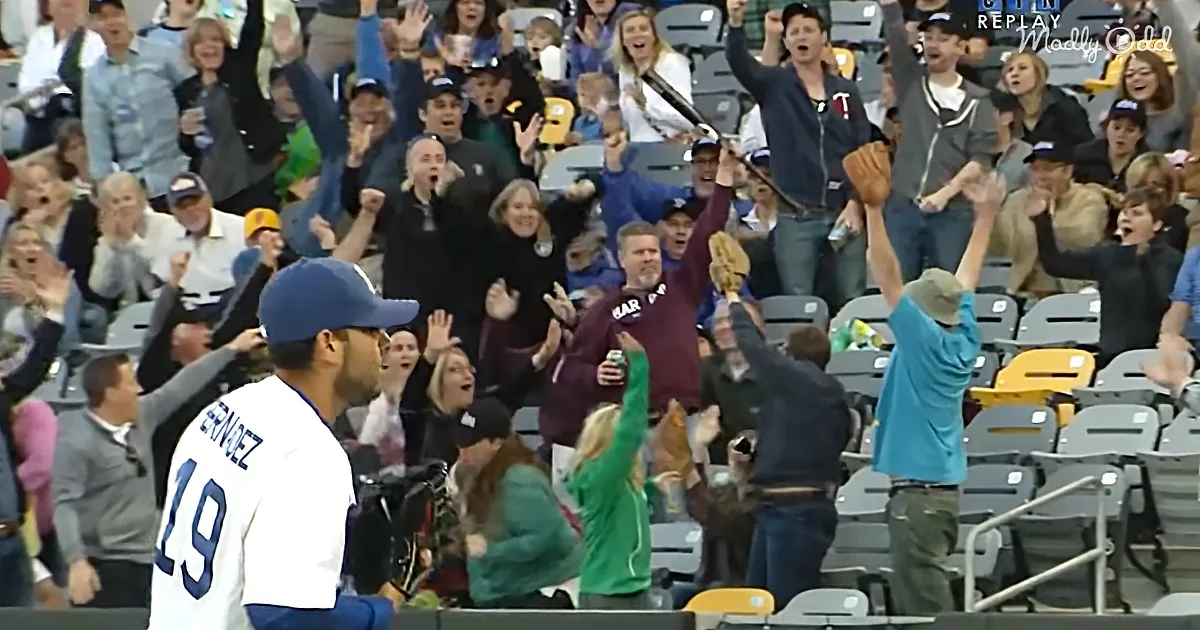 A baseball player in a white jersey with number 19 interacts with a cheering crowd at a stadium.