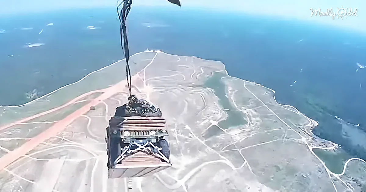 A parachute descends over a coastal landscape, revealing roads and water below.