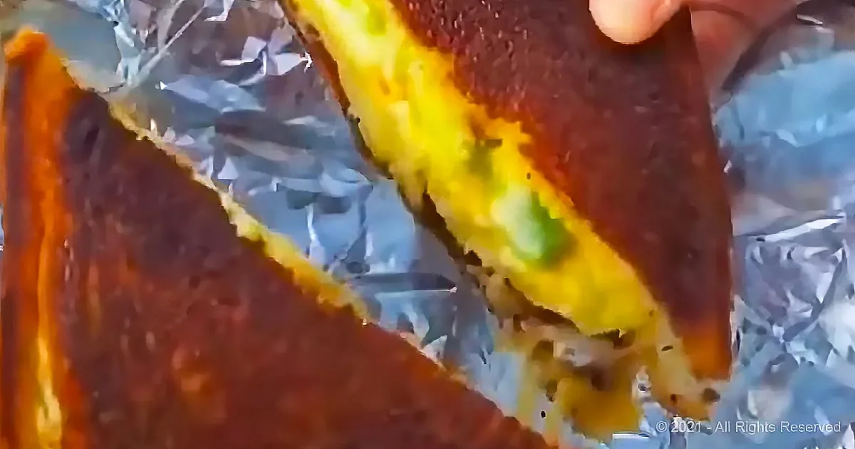 A close-up of a partially eaten sandwich with a bite taken out, revealing the filling.