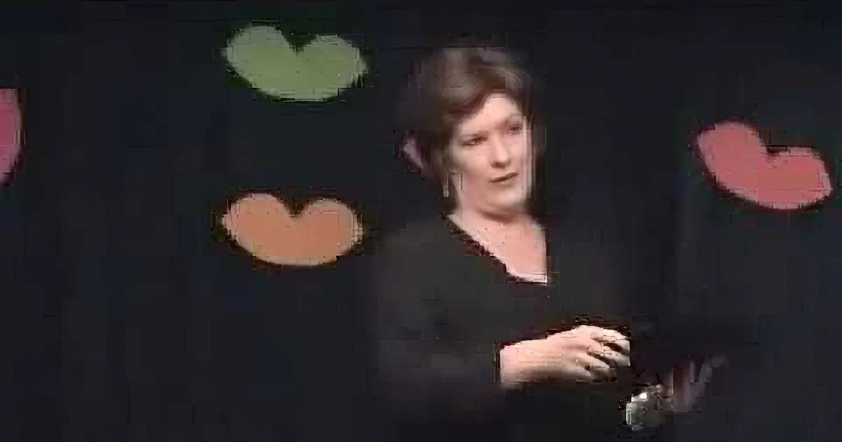 A woman with short hair and earrings is smiling, wearing a black outfit, with colorful shapes in the background.
