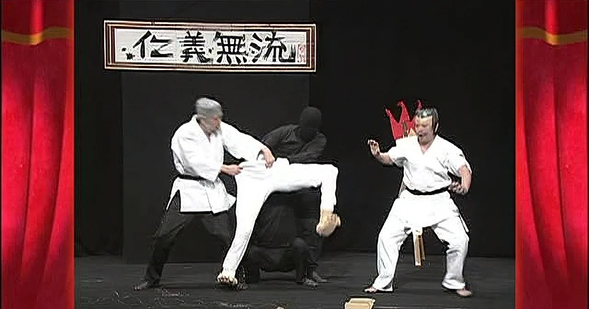 Two men in white karate uniforms practicing martial arts, one holding a wooden stick.