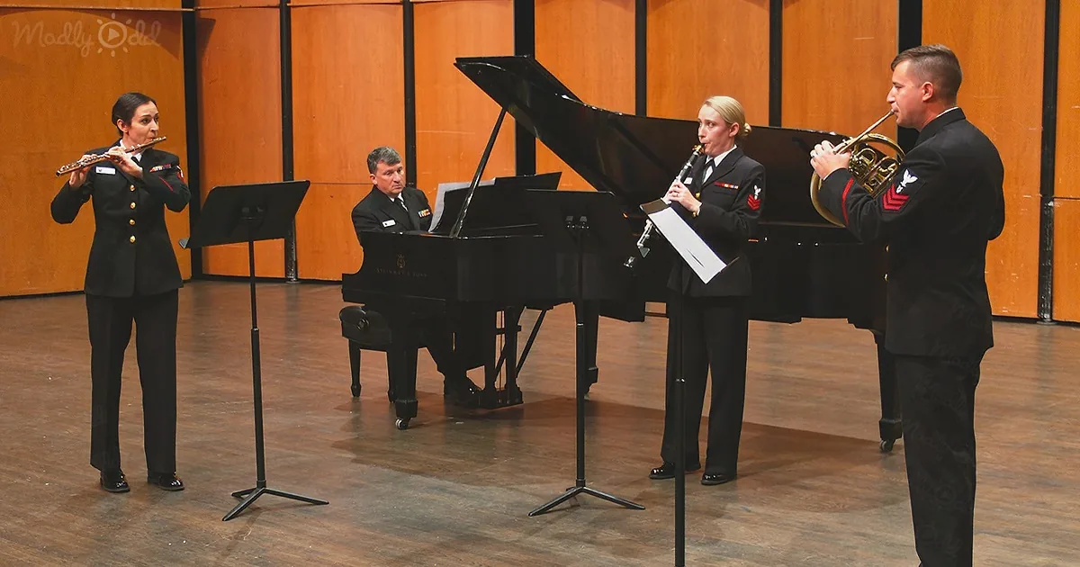 A group of musicians in uniform play instruments in front of a grand piano.