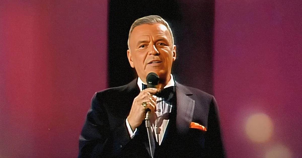 Frank Sinatra in a tuxedo holding a microphone, singing on stage.