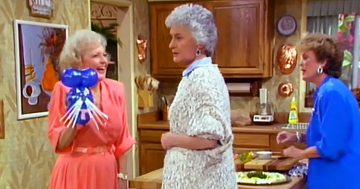 A woman in a pink dress holds blue balloons, smiling, while another in a white lace dress looks on, and a third in a blue...