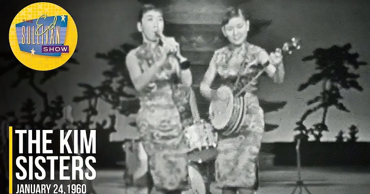 A band performs on stage with a drummer, saxophonist, and vocalist in traditional attire.