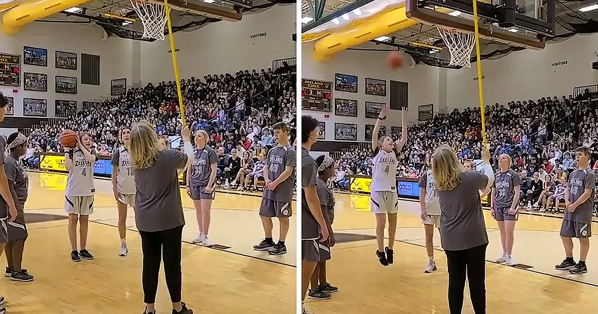 A young girl in a white jersey prepares to shoot a basketball while a coach and teammates watch.