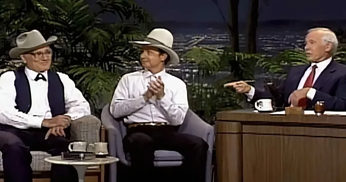Three men in cowboy hats seated on a talk show set, with one man in a suit and tie gesturing.