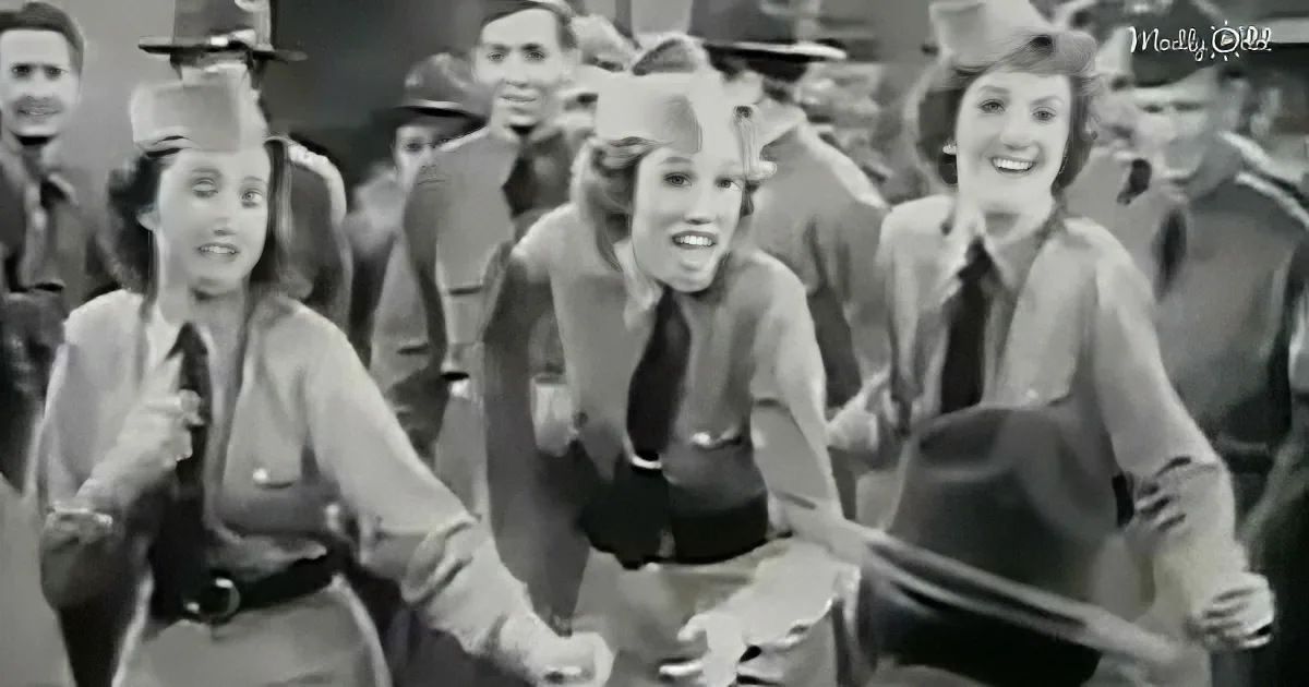 Women in uniform dance and sing in a lively group, surrounded by onlookers.