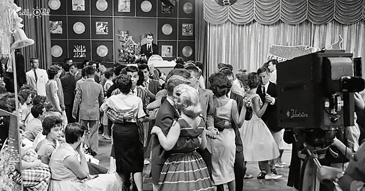 A lively dance scene with couples in vintage attire, a camera capturing the moment, and a festive backdrop.