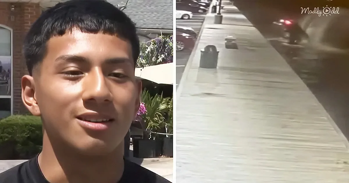 A young man stands outdoors, smiling, with a sidewalk and parked cars visible in the background.