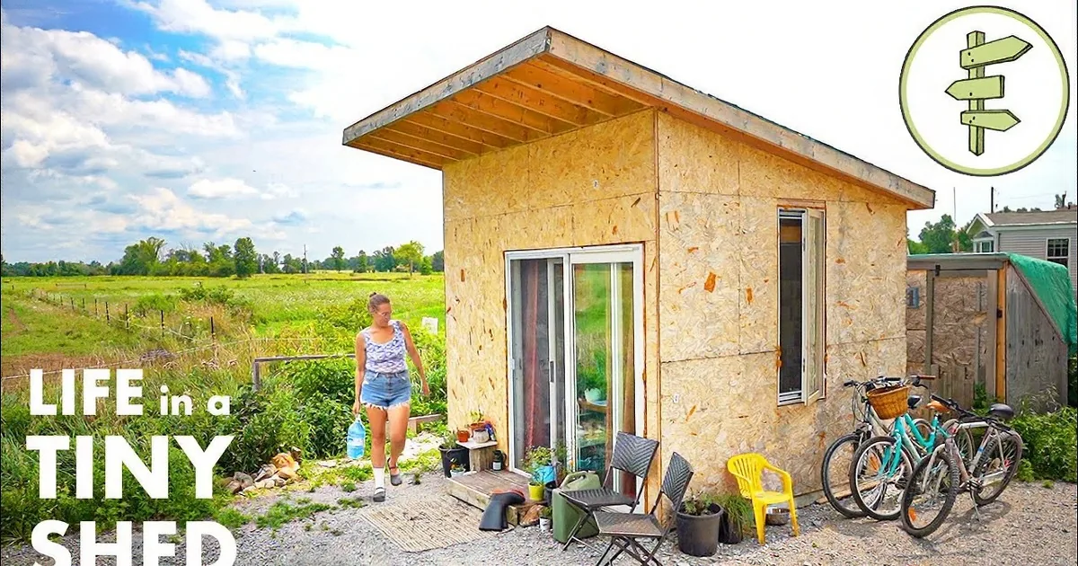 A cozy, small wooden cabin with warm interior light, surrounded by bicycles and outdoor furniture, set against a serene...
