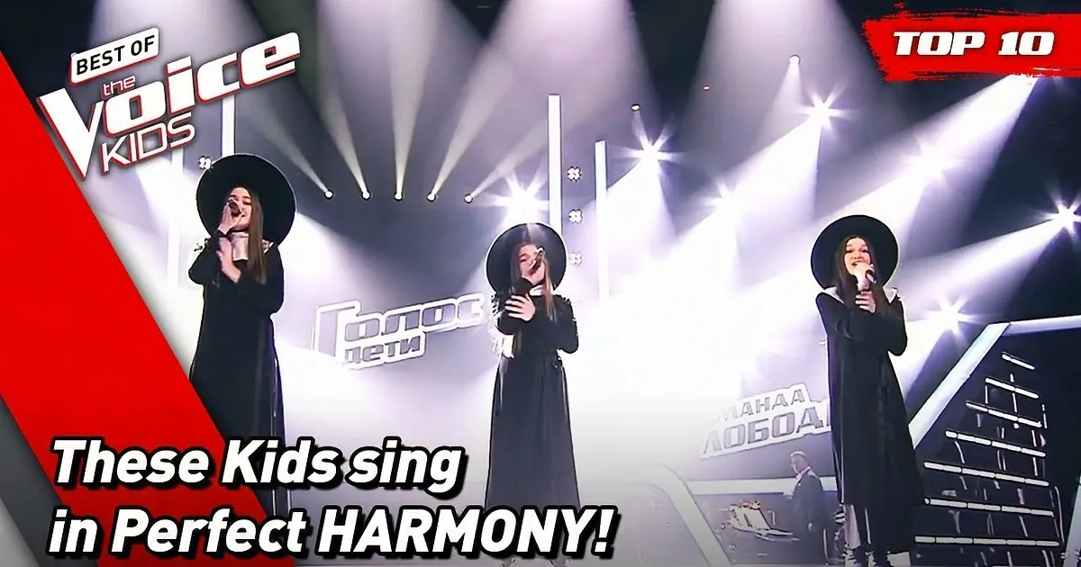 Two girls perform on stage, one singing into a microphone while the other plays piano.