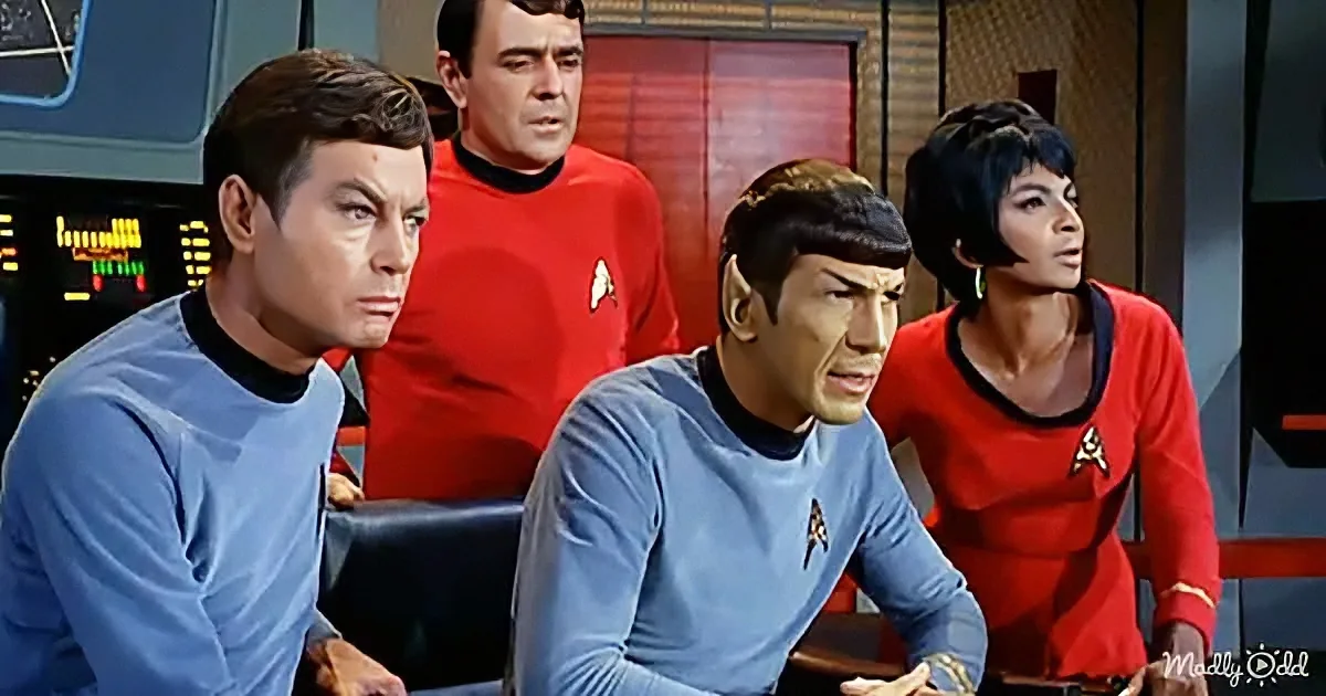 Spock and crew in blue and red uniforms on a spaceship, looking concerned.