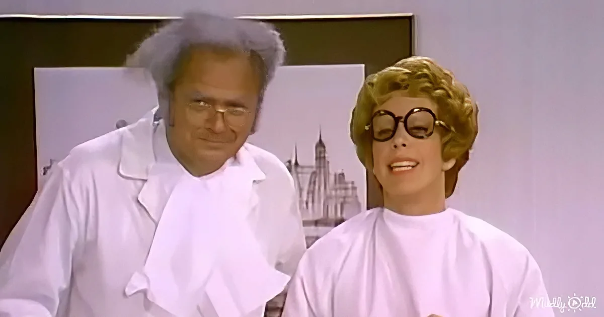 A man in a lab coat and a woman in a white cape are smiling, possibly in a lab or medical setting.