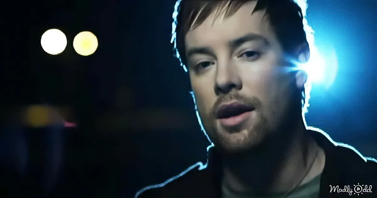 A man with a beard and short hair, wearing headphones, is illuminated by a bright light source.