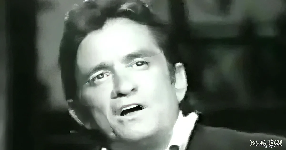 A man with curly hair, wearing a suit, appears to be speaking or singing in a black-and-white image.