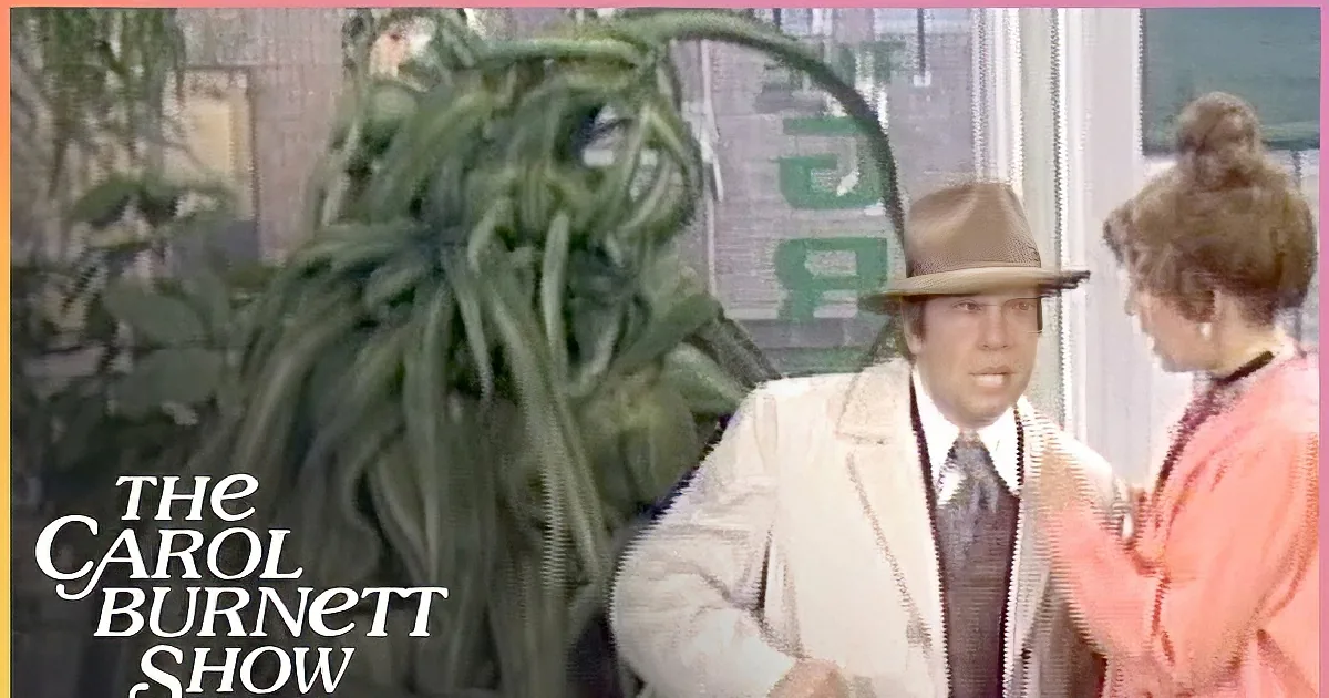 A man in a white coat and hat stands next to a large, plant-like creature with long, green tendrils.