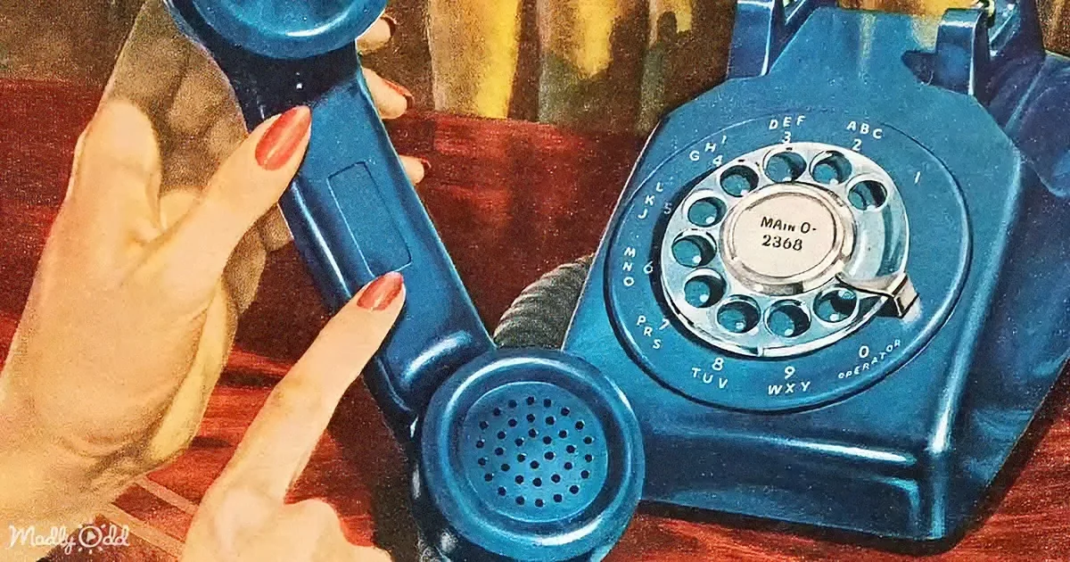 A vintage blue rotary phone with a dial and handset held by a hand with red nail polish.