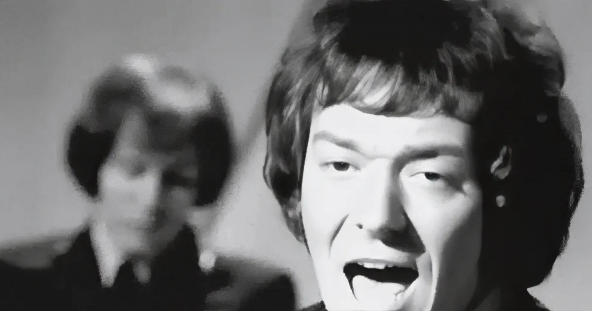 A woman with closed eyes sings into a microphone, her hand near her mouth, in a black-and-white image.