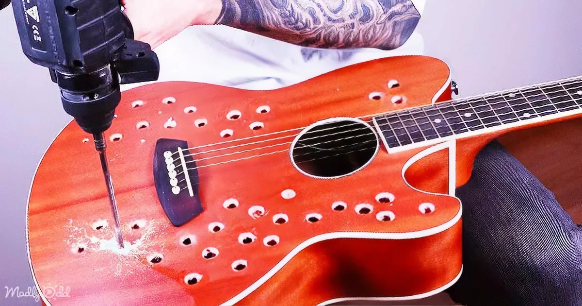 A person drills holes in a red guitar body with a power drill.
