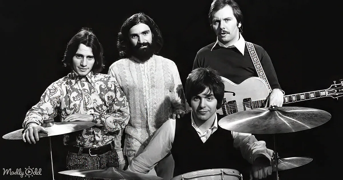 A black-and-white photo of a band with a drummer, guitarist, and two other musicians.