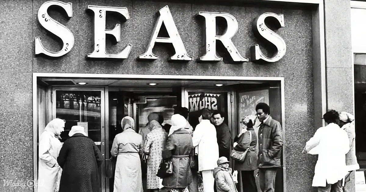 People queue outside a Sears store, with large "SEARS" sign above the entrance.