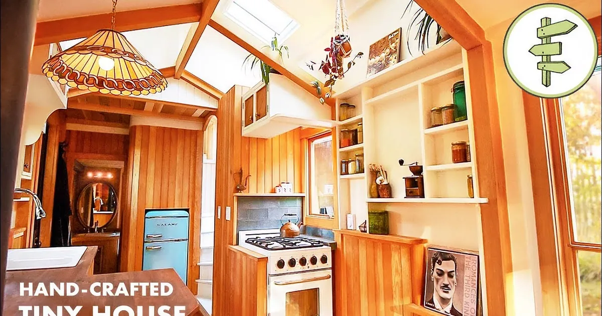 A cozy kitchen with wooden cabinets, a gas stove, and a stained glass pendant light.