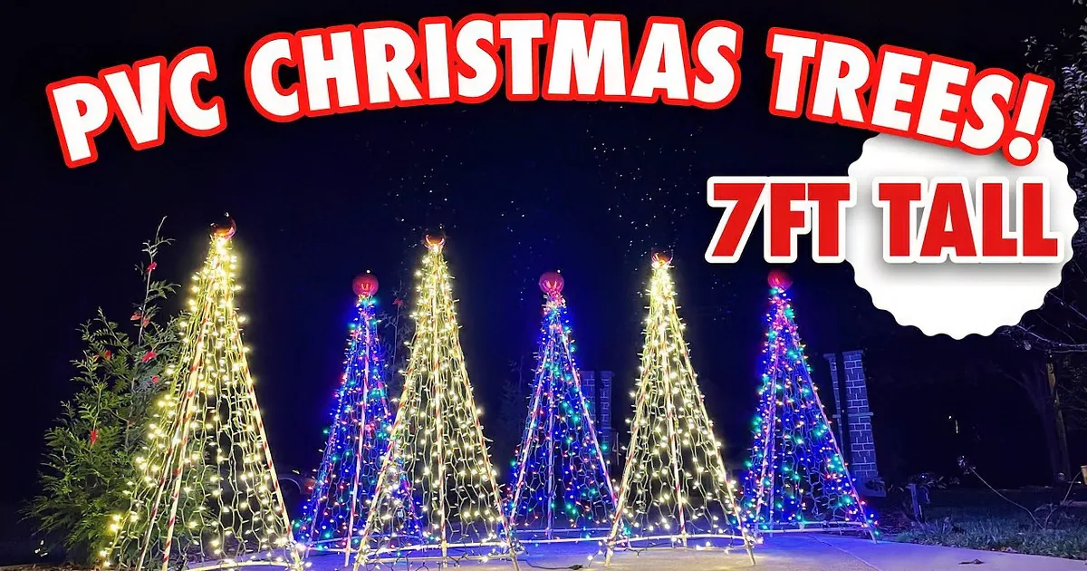 I see colorful, illuminated Christmas tree-shaped lights in a grassy area at night.