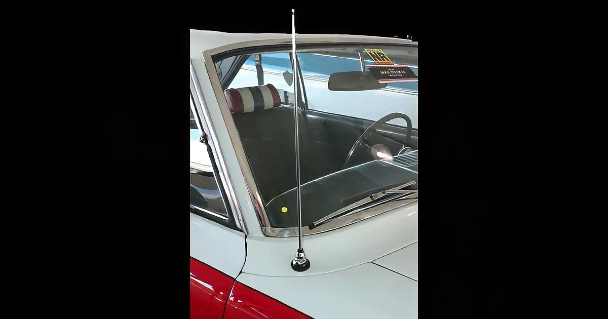 A vintage car interior with a gold door handle, a cassette tape, and a woman in a retro outfit sitting in the back seat.