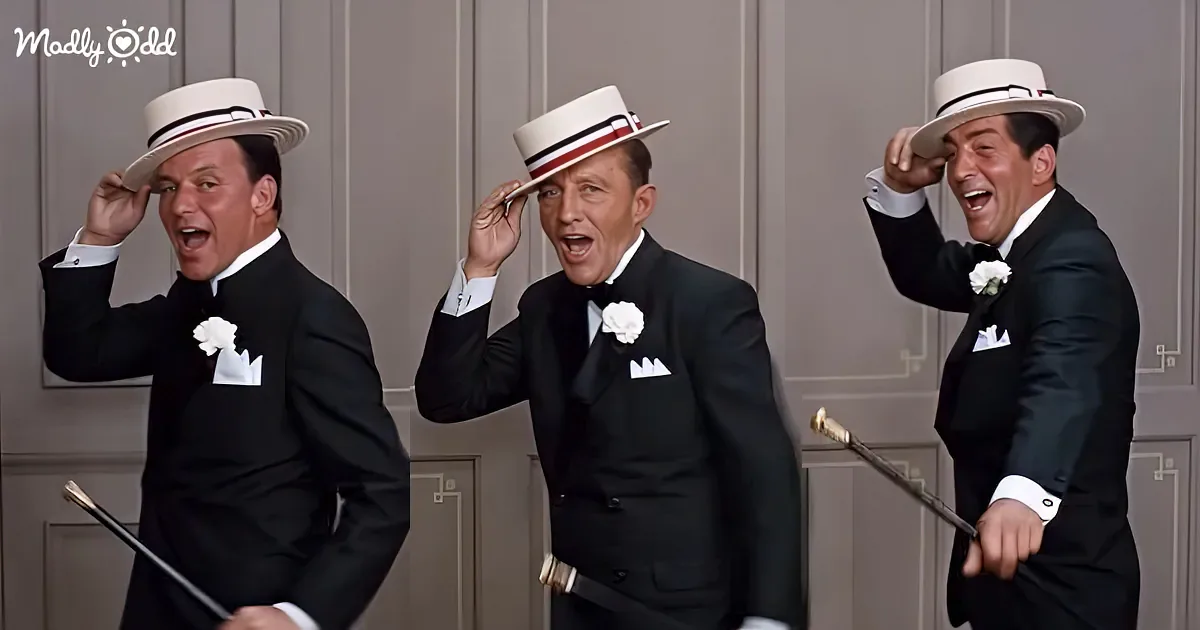 Three men in tuxedos and top hats are laughing and adjusting their hats.