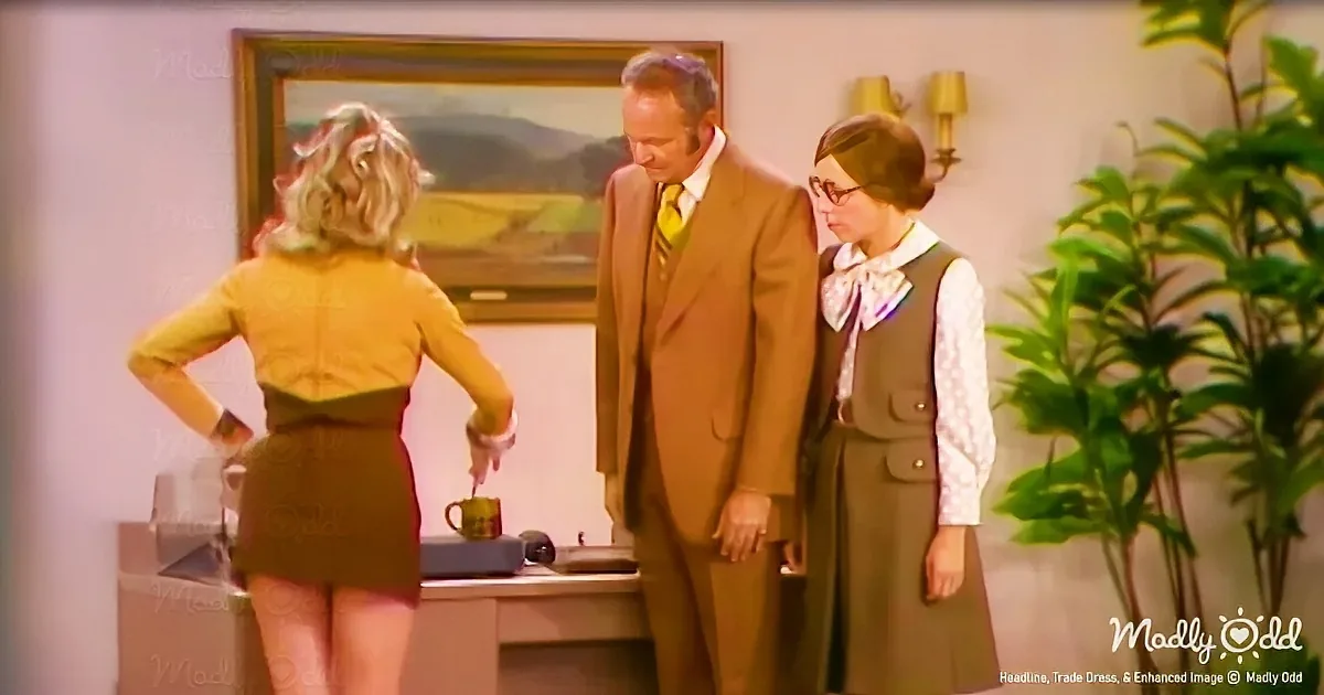 A woman in a yellow dress stands with hands on hips, facing a man in a brown suit and another woman in a green vest and...